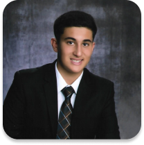 Portrait of young adult male in a suit in front of a blue brushed background