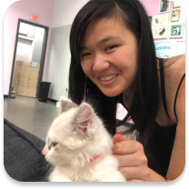 Young Adult female smiling next to a white kitten